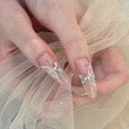 Close-up of hands with butterfly nail art on sheer fabric