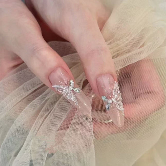 Close-up of hands with butterfly nail art on sheer fabric