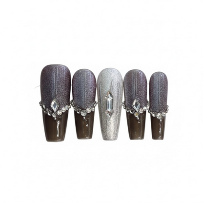 Set of five decorative nails with gemstone accents on a white background