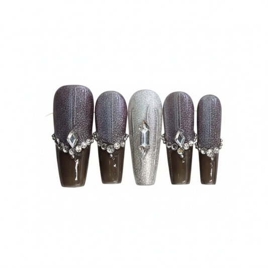 Set of five decorative nails with gemstone accents on a white background