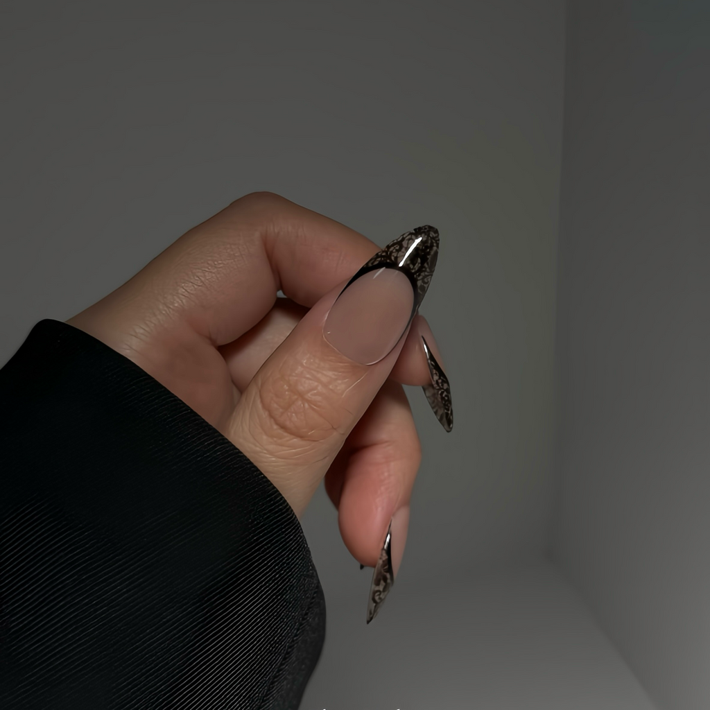 Hand holding a small metallic object against a neutral background