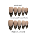 Handmade press-on nails with black lace design on a white background, labeled 'ABLE Nail'.