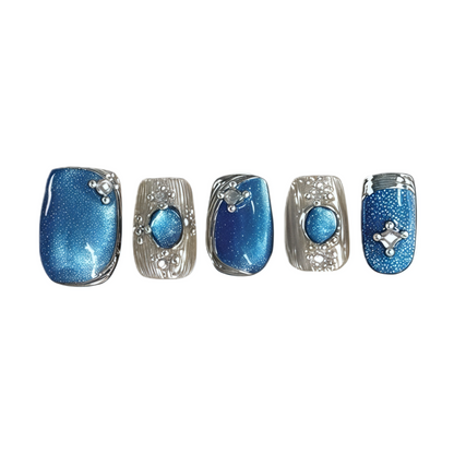 Five blue nail designs with silver accents on a white background
