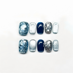 Nail art display with blue and silver designs on a white background