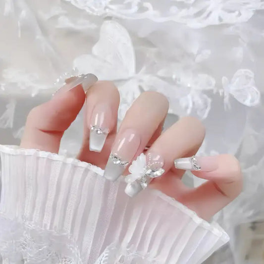Hand with decorative nails against a white lace background
