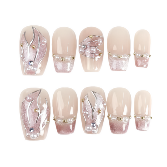 Set of decorative false nails with floral designs and pearls on a white background