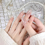 Close-up of hands with decorative nail art against a shell-patterned background