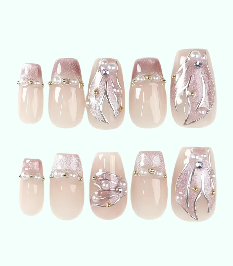 Set of decorative nail art with pearls and gold accents on a white background