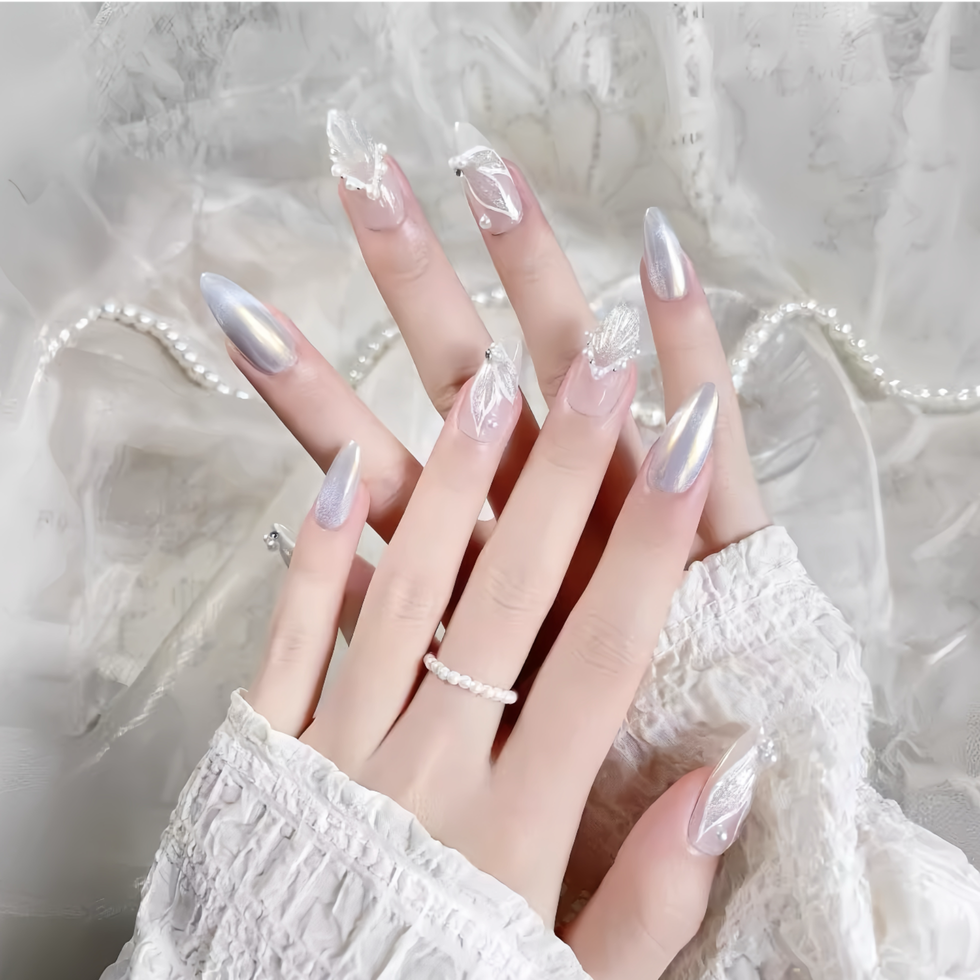 Hand with long, decorative nails against a soft, neutral background
