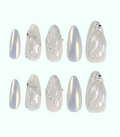 Set of decorative nail art tips with silver and white designs on a white background