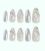 Set of decorative nail art tips with silver and white designs on a white background