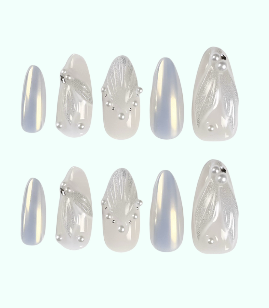 Set of decorative nail art tips with silver and white designs on a white background