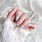 Hand with decorative nails on a textured white background