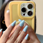 Close-up of a hand with light blue nail polish holding a yellow phone case.