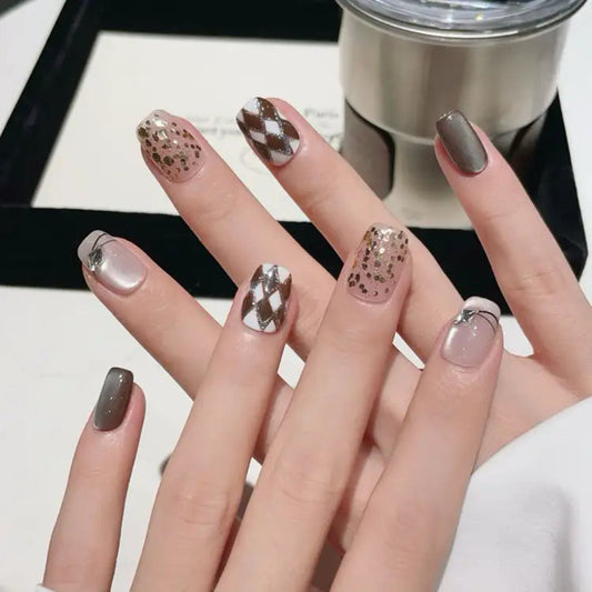 Close-up of hands with decorative nail art holding a small container.