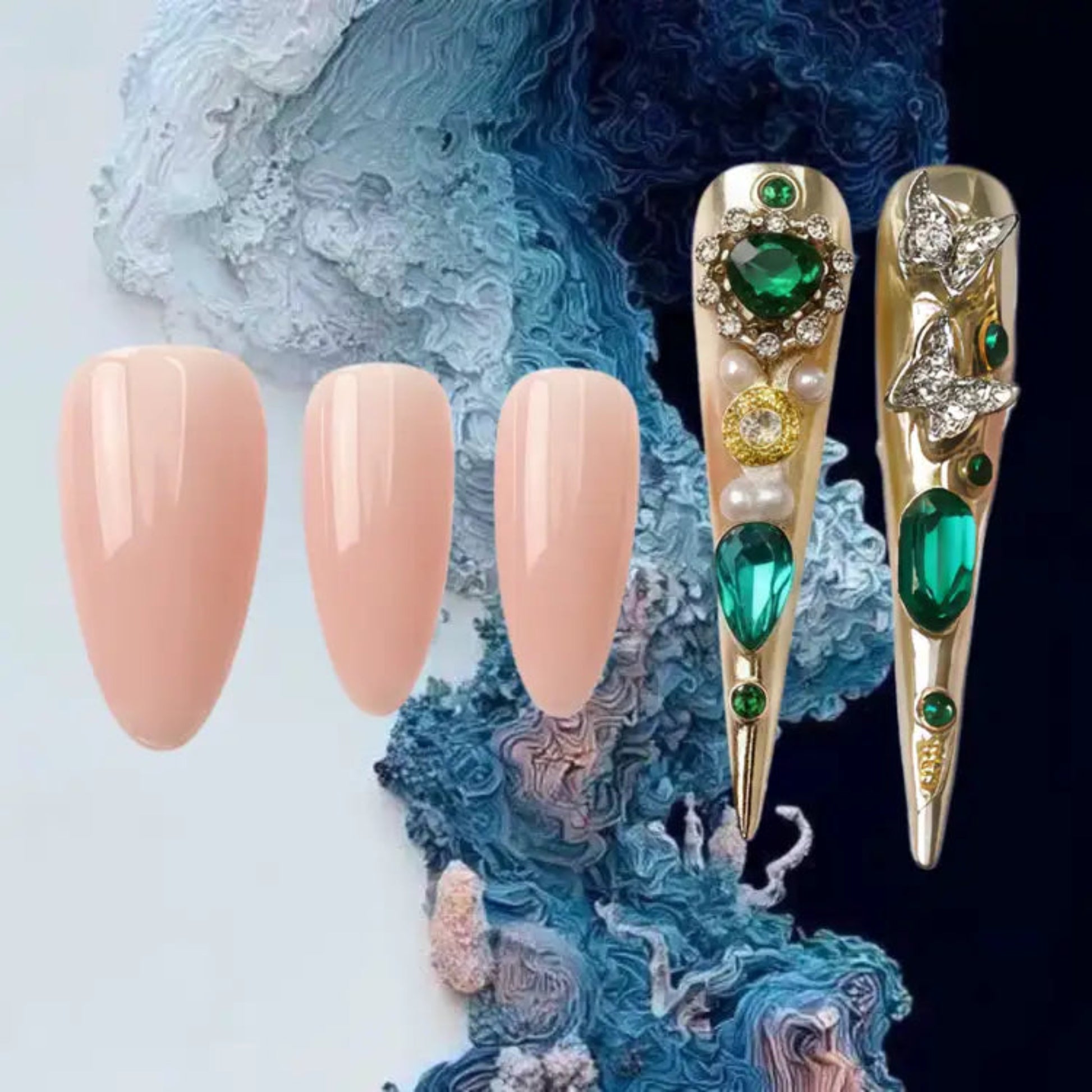 Decorative nail tips with gold and green gemstones on a textured blue and white background