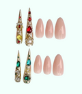 Decorative nail tips with gemstones and plain pink nails on a white background