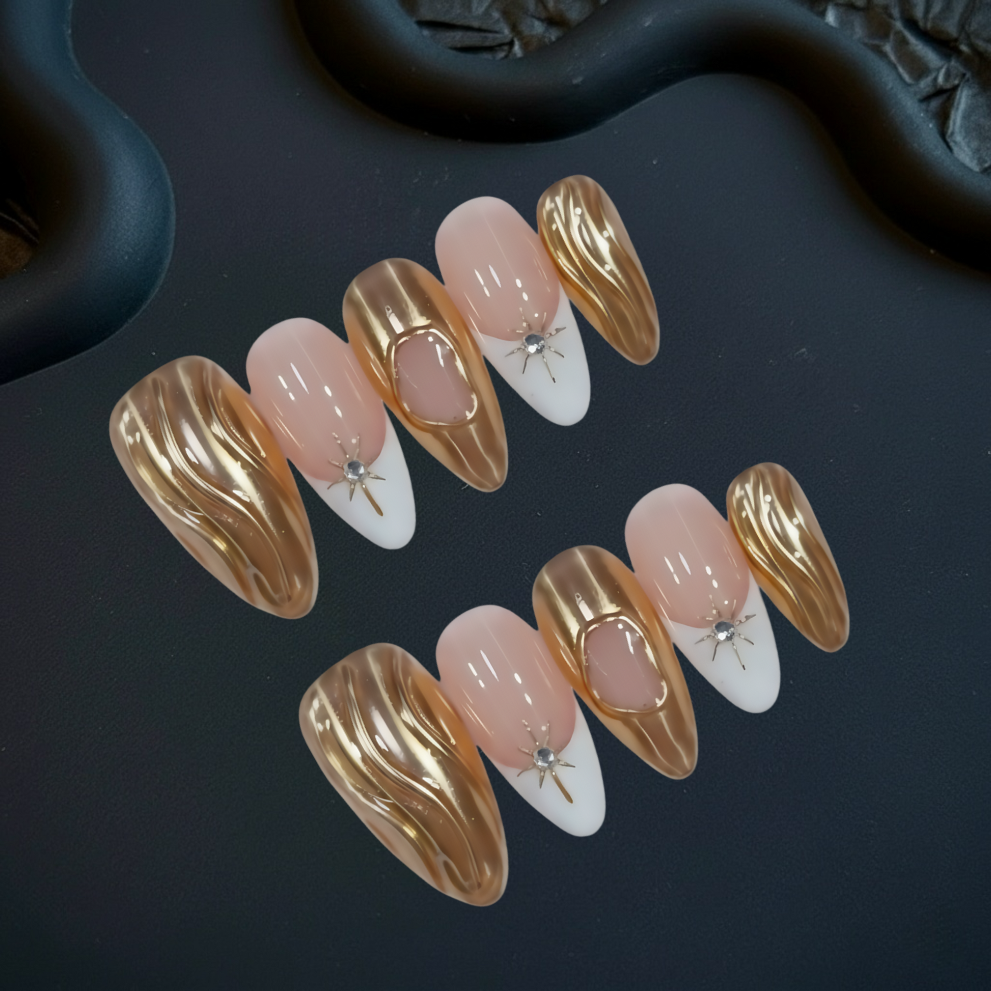 Set of gold, pink, and white nail art designs on a dark surface