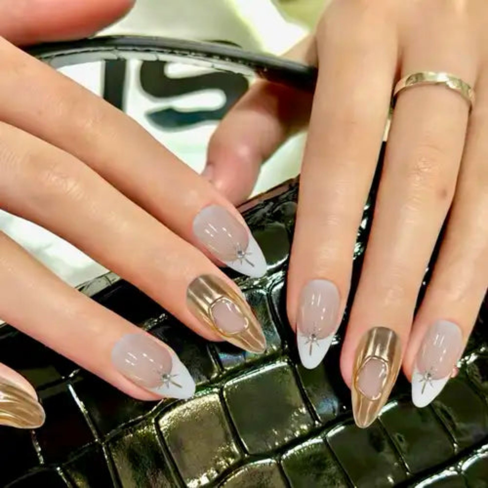 Close-up of hands with decorative nail art on a textured surface