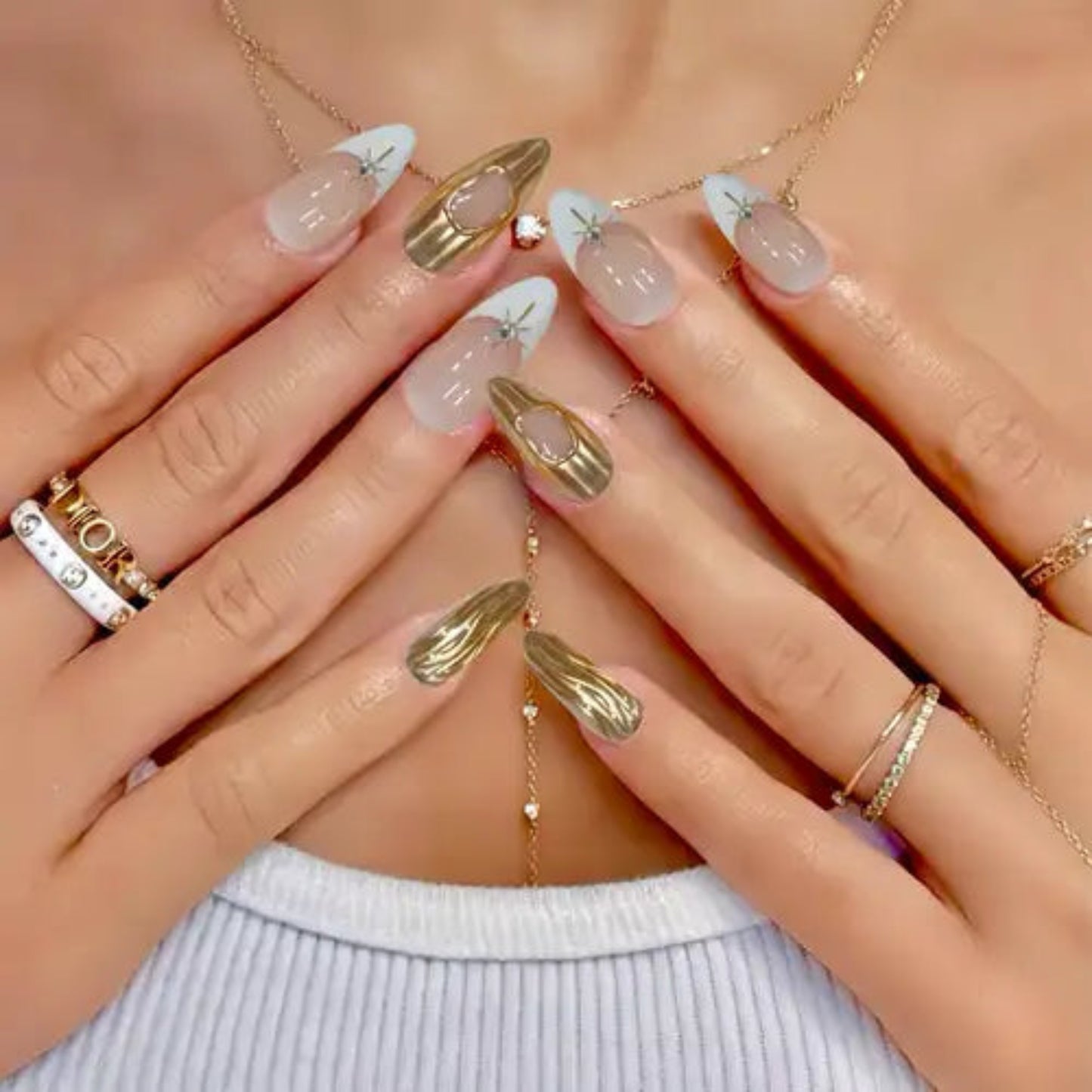Close-up of hands with decorative nails and gold jewelry