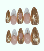 Set of nail art designs with gold, pink, and white colors on a white background