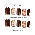 Handmade press-on nails with floral design and brown base color, labeled 'ABLE Nail'.