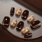 Nail art designs on a white plate with a brown fabric background