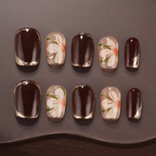 Nail art with floral designs on a dark background