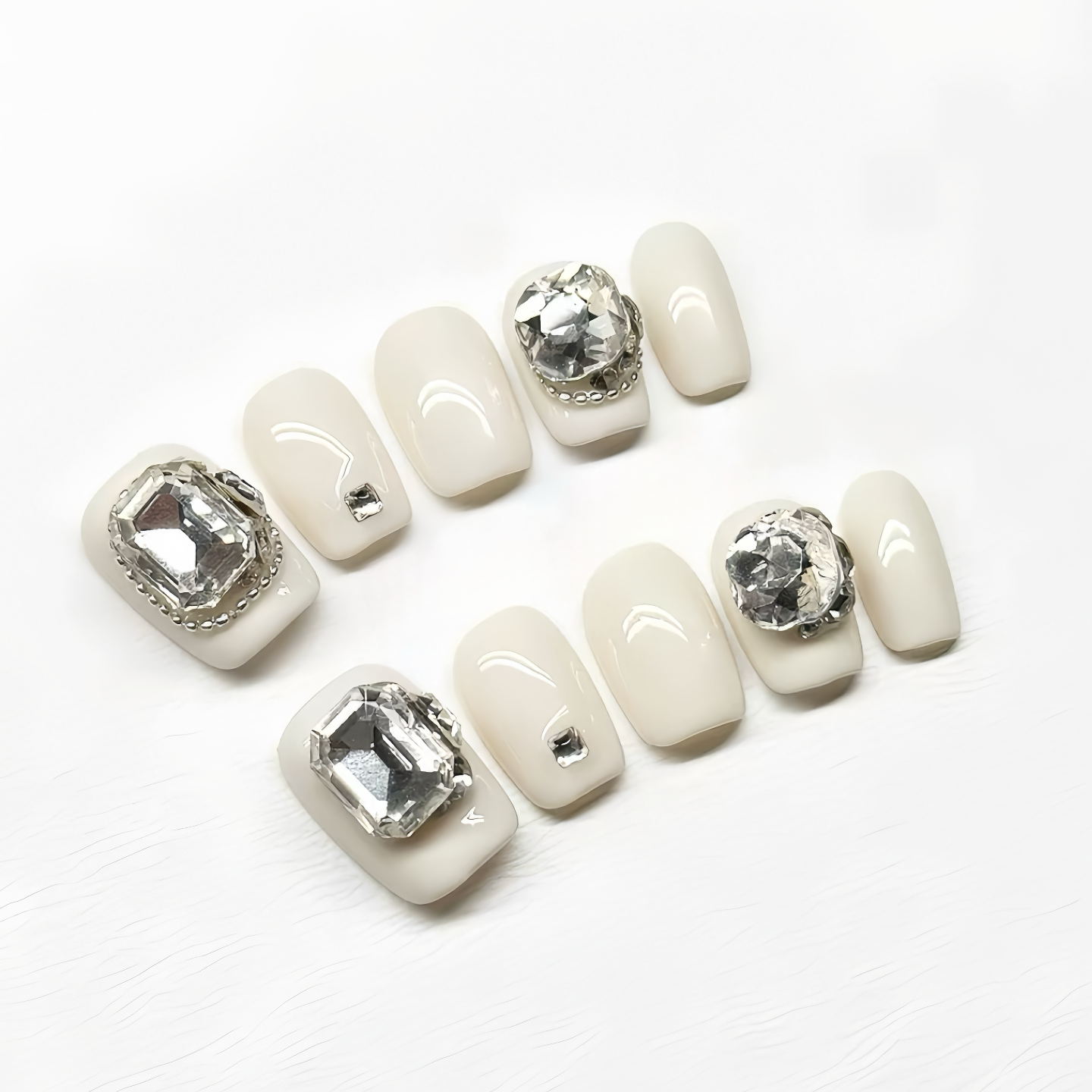 Set of white nail art stickers with rhinestone decorations on a white background