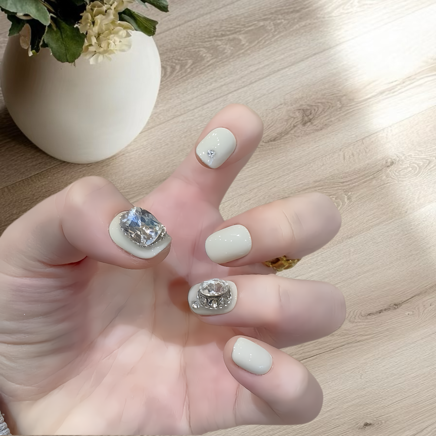 Hand with decorative nails on a wooden surface