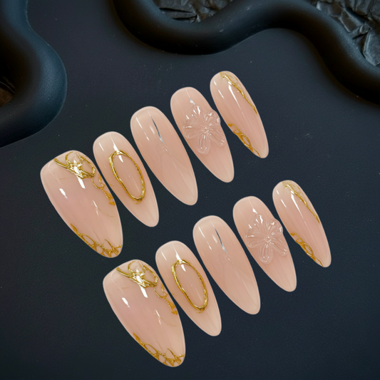Set of pink nail art designs with gold accents on a dark surface