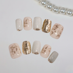 Set of decorative nails with gold and silver accents on a white background