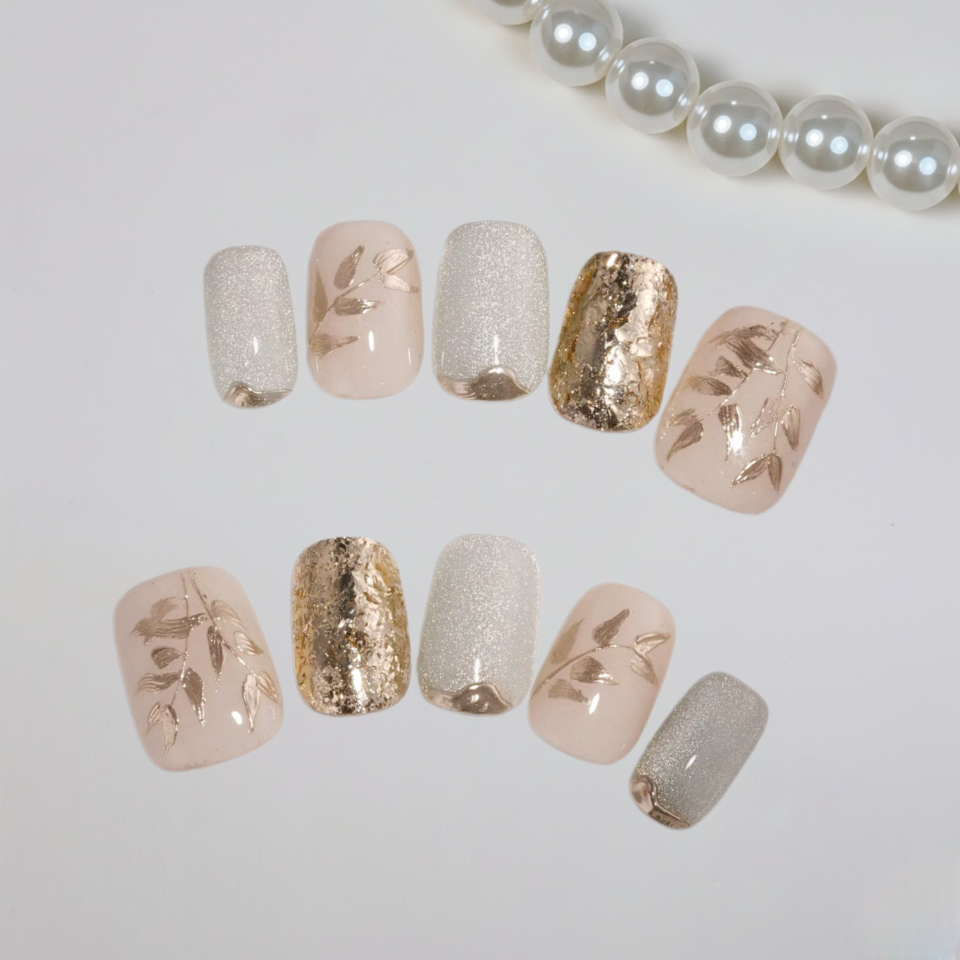 Set of decorative nails with gold and silver accents on a white background