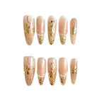Set of beige nail extensions with gold floral designs on a white background