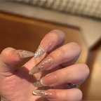Close-up of a hand with decorative nail art on a neutral background
