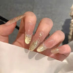 Hand with gold and clear nail polish on a neutral background