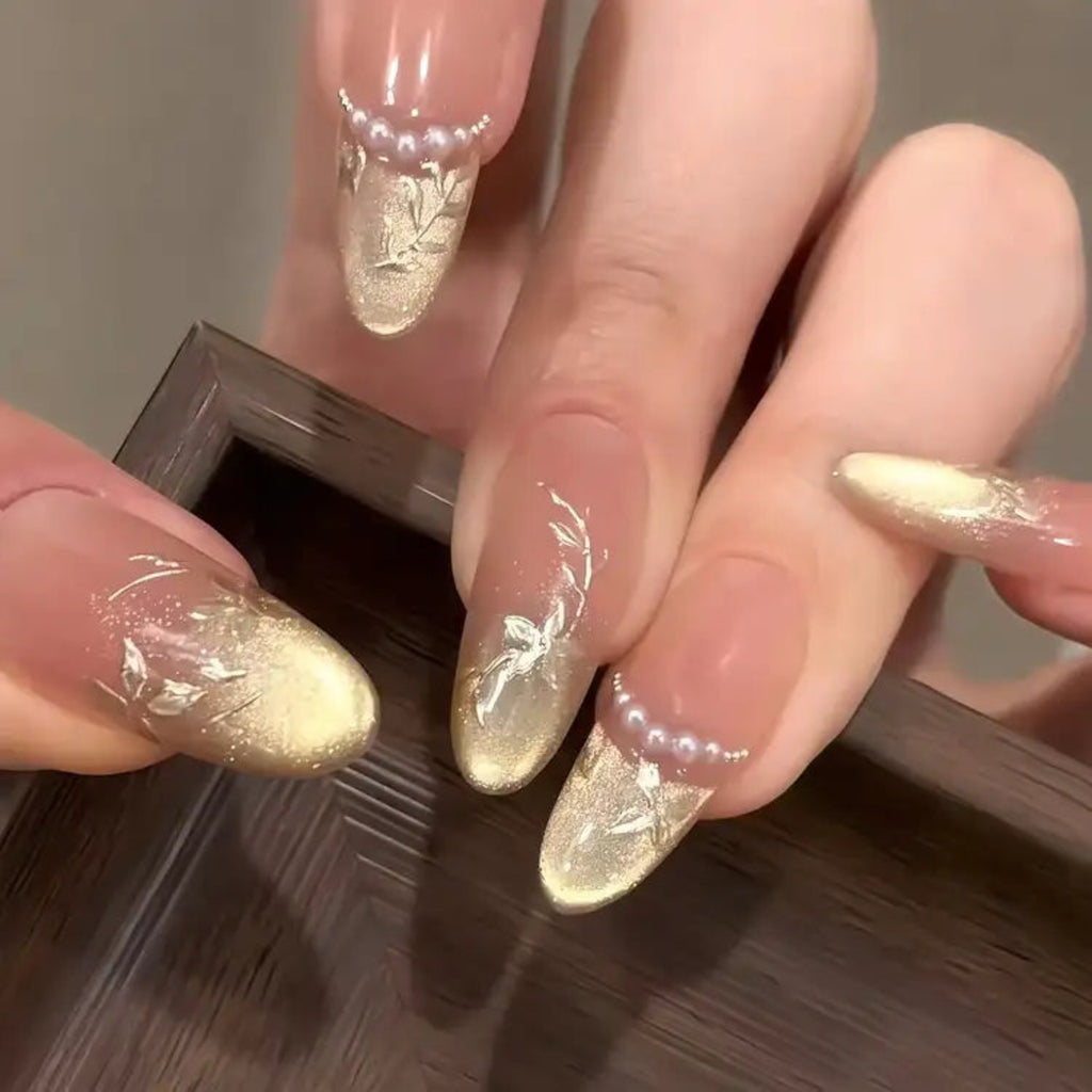 Close-up of a hand with decorative nail art on a wooden surface