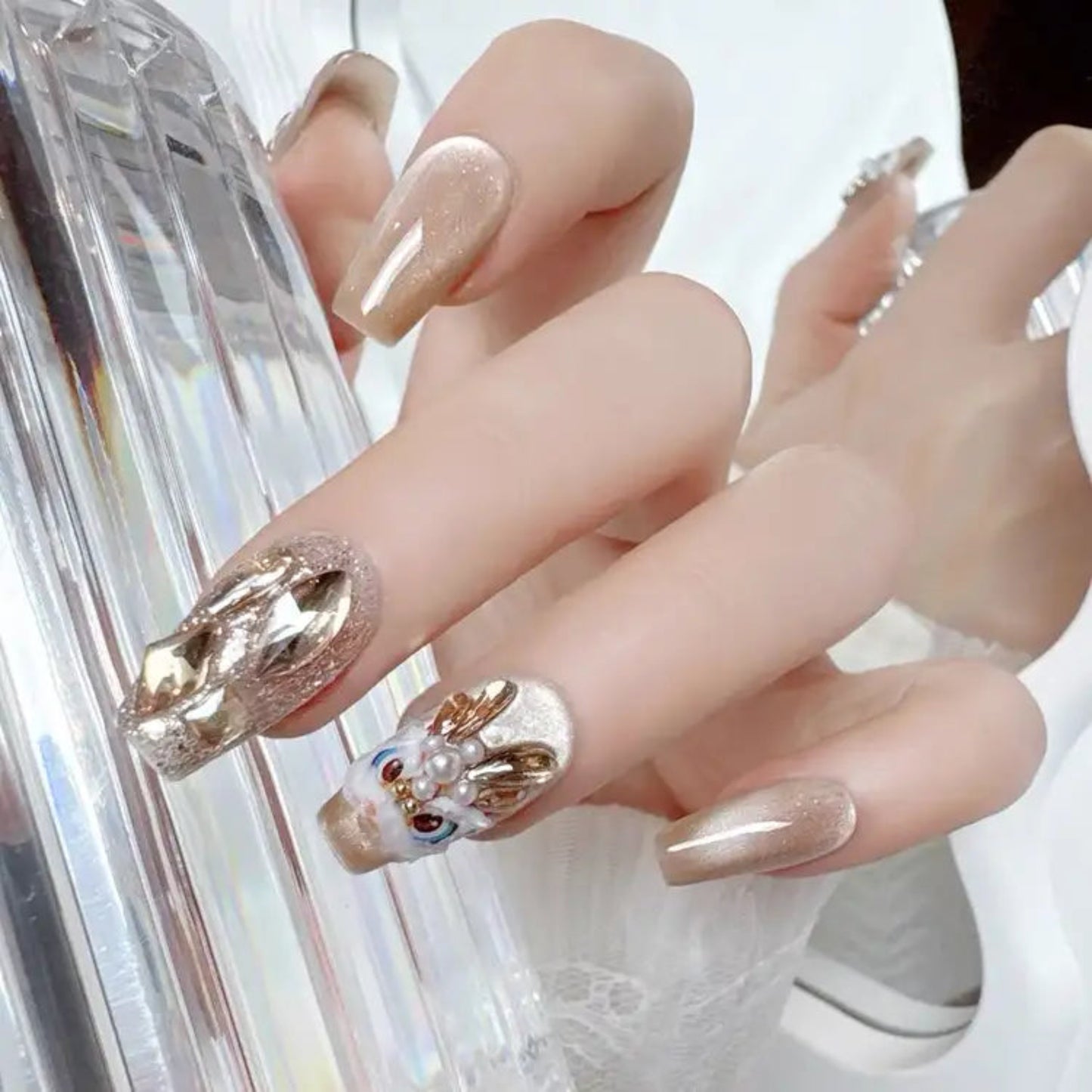 Close-up of hands with decorative nail art holding a phone.