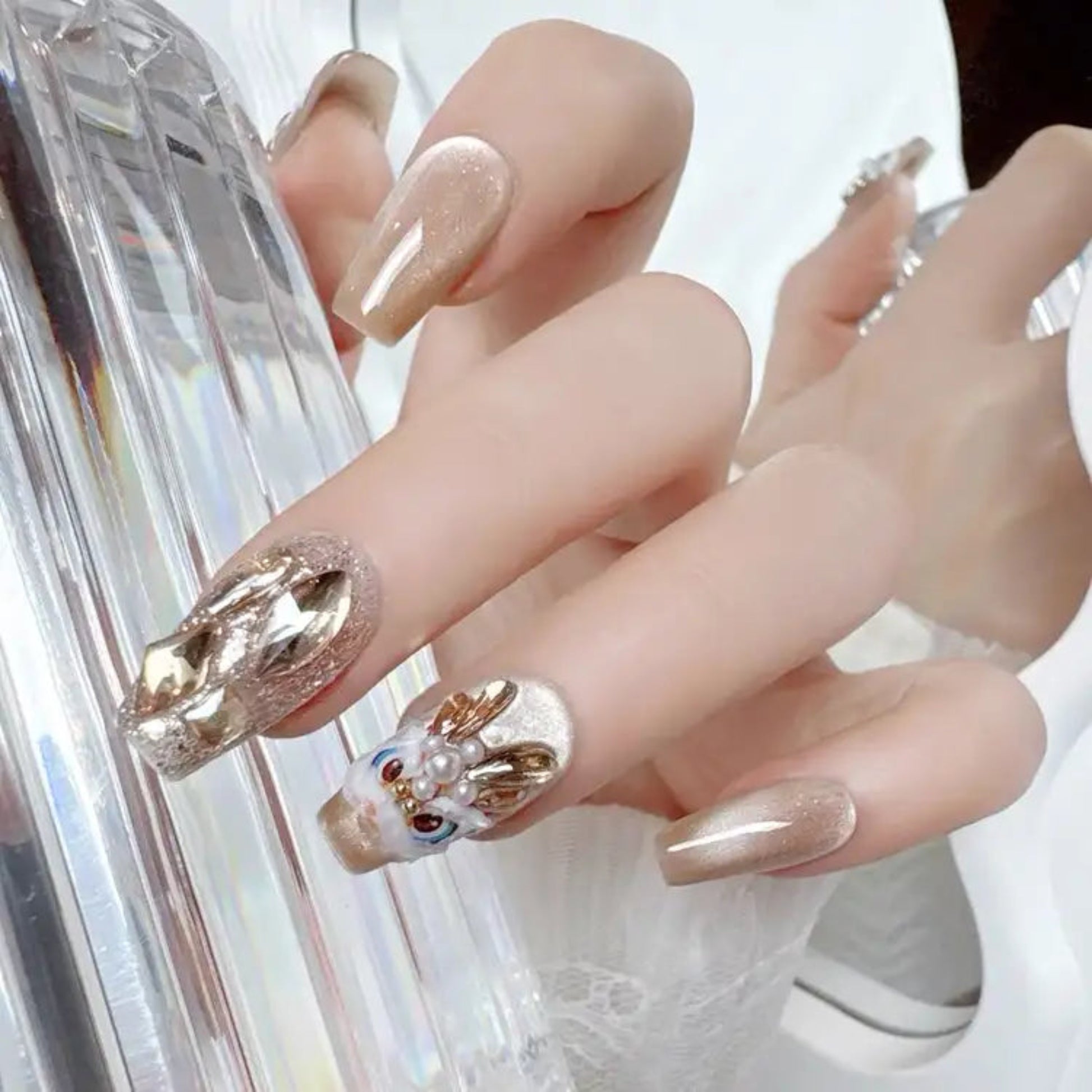 Close-up of hands with decorative nail art holding a phone.