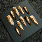 Set of gold and brown nail art designs on a black surface