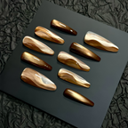 Set of brown and gold nail designs on a black surface with a textured black background