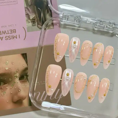 Set of pink nail art designs with gold accents in a clear display case.