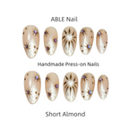 Handmade press-on nails with decorative designs on a white background, labeled 'ABLE Nail'.
