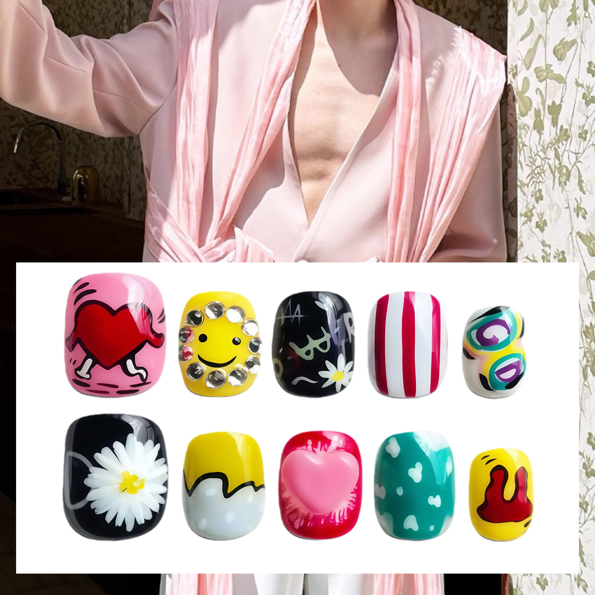 Person wearing a pink robe with a close-up of colorful nail art designs.