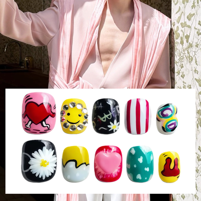 Person wearing a pink robe with a close-up of colorful nail art designs.