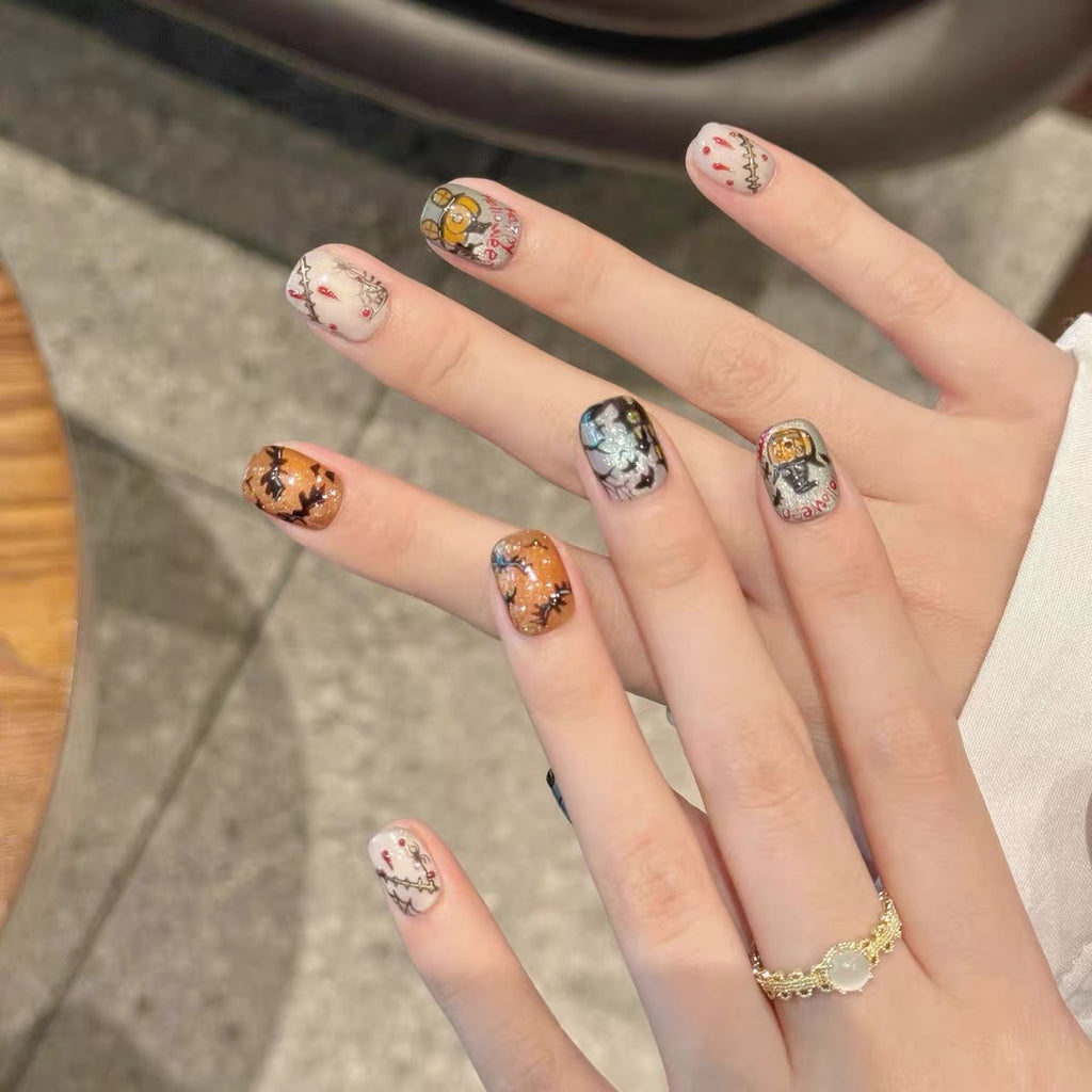 Close-up of a hand with intricately designed nails, wearing a gold ring.