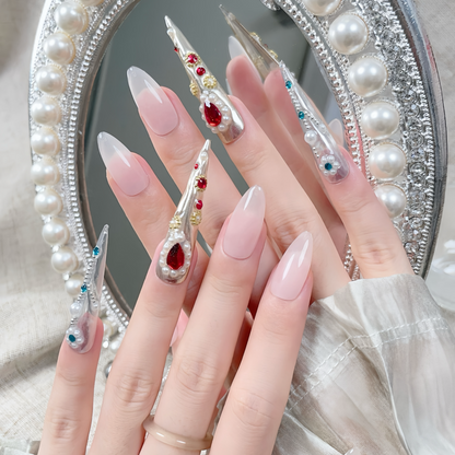 Close-up of hands with decorative nail art in front of a decorative mirror.