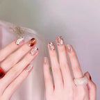 Close-up of hands with decorative nail art on a neutral background