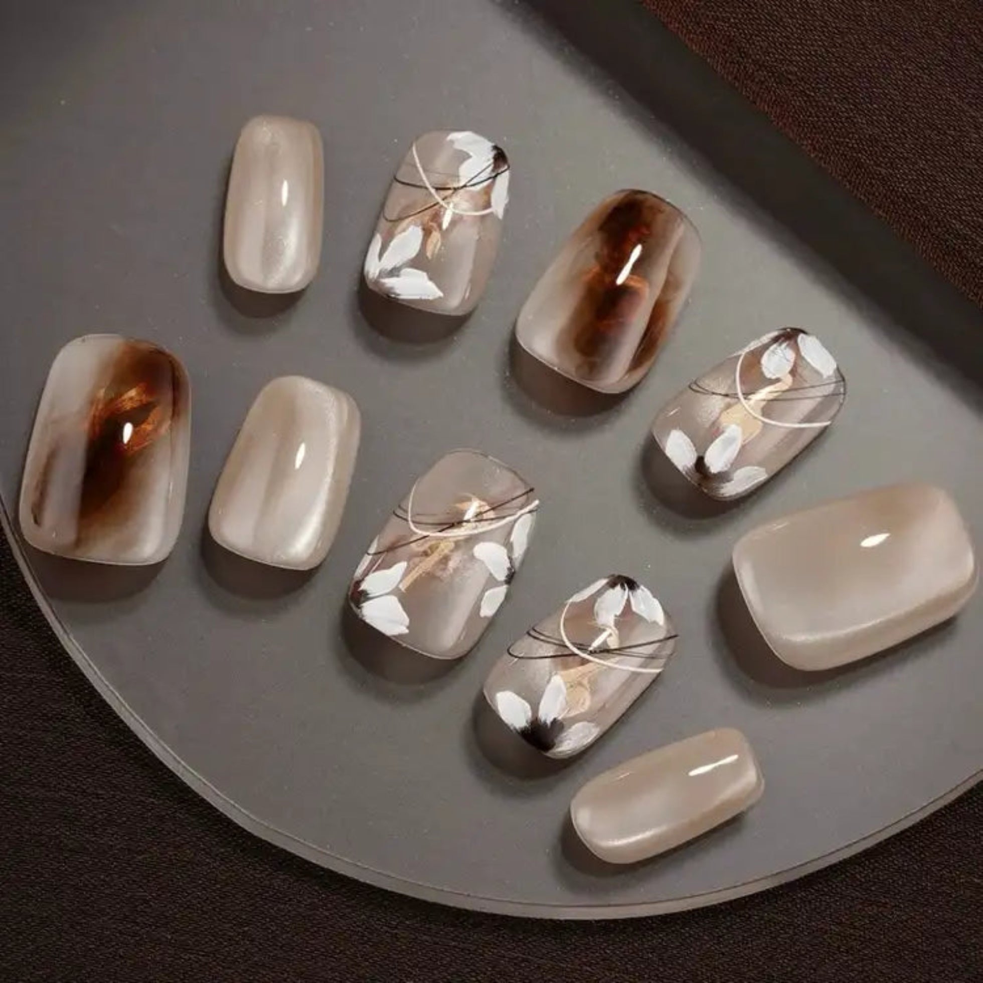 Set of nail art designs on a gray surface