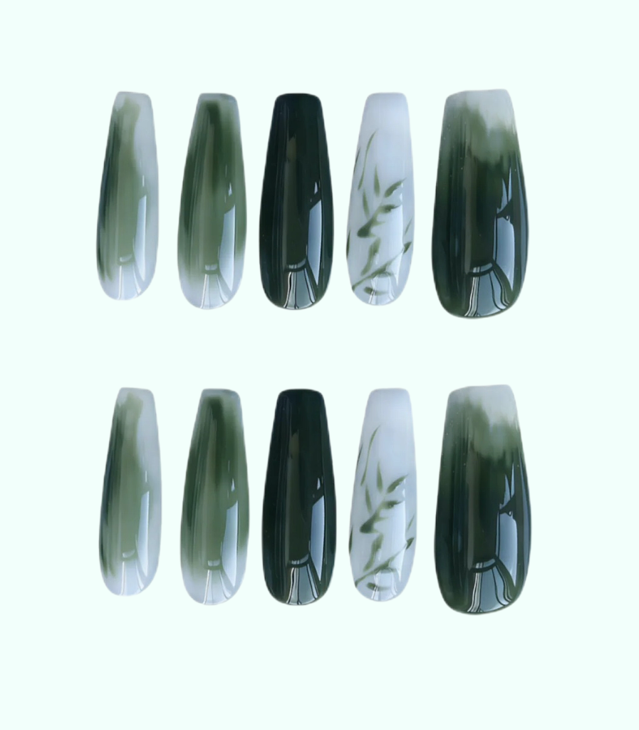 Set of green and black nail extensions on a white background